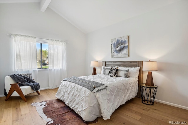 bedroom featuring baseboards, high vaulted ceiling, beam ceiling, and wood finished floors