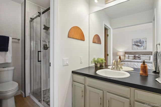 full bathroom featuring vanity, wood finished floors, toilet, and a shower stall