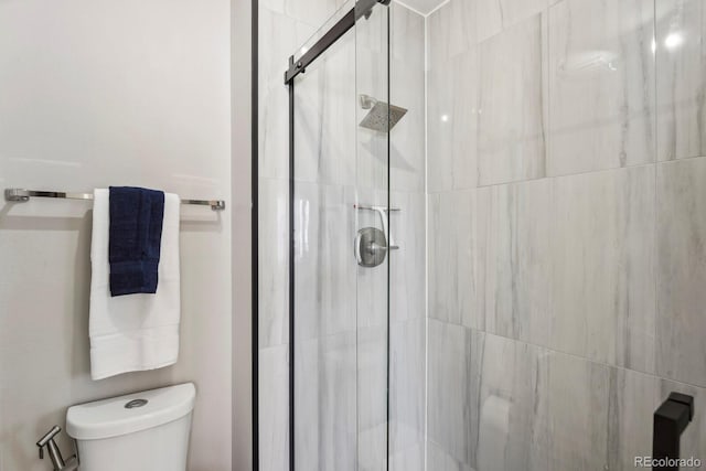 bathroom featuring a shower stall and toilet