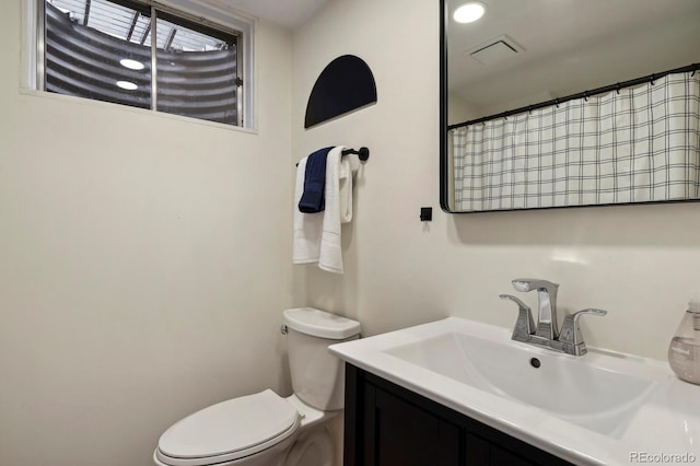 bathroom with vanity, visible vents, and toilet