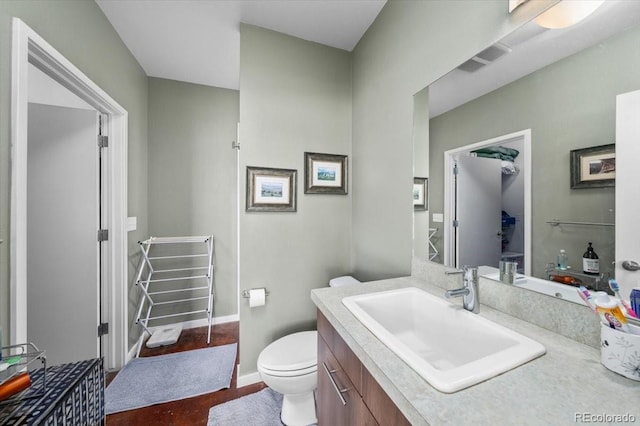 bathroom featuring vanity, hardwood / wood-style floors, and toilet