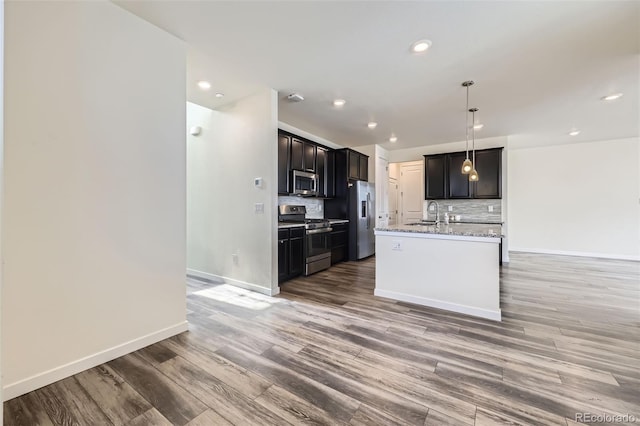 17530 E 95th Ave, Commerce City, CO 80022 - kitchen with appliances with stainless steel finishes, tasteful backsplash, light wood finished floors, recessed lighting, and baseboards