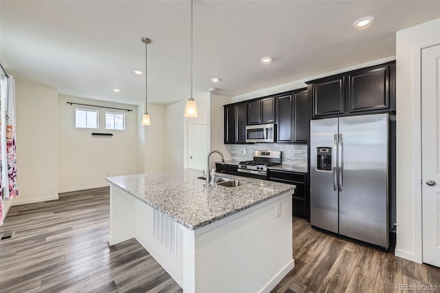 17530 E 95th Ave, Commerce City, CO 80022 - kitchen featuring appliances with stainless steel finishes, a sink, dark wood-style floors, a center island with sink, and recessed lighting