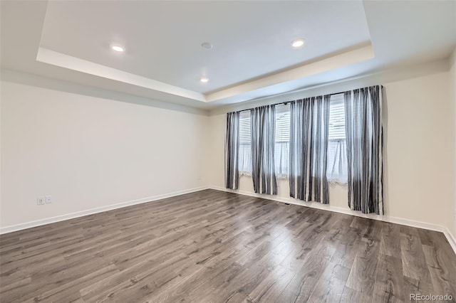 17530 E 95th Ave, Commerce City, CO 80022 - empty room featuring a tray ceiling, dark wood-style floors, baseboards, and recessed lighting