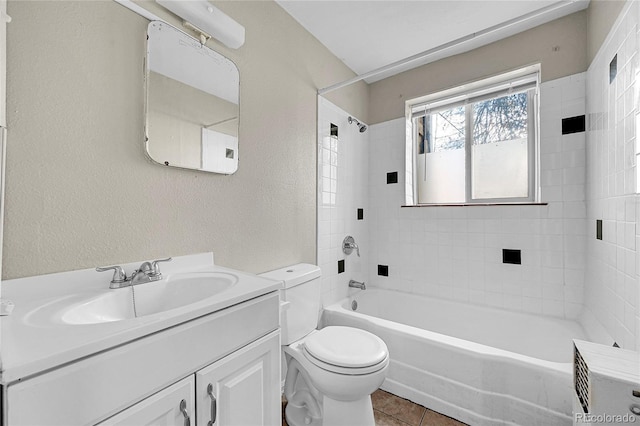 full bathroom featuring tile patterned flooring, vanity, toilet, and tiled shower / bath