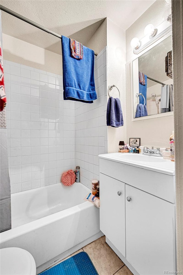 full bathroom with vanity, tile patterned flooring, toilet, shower / bathtub combination with curtain, and a textured ceiling