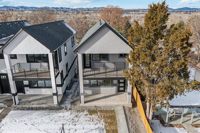 back of house featuring a mountain view and a balcony