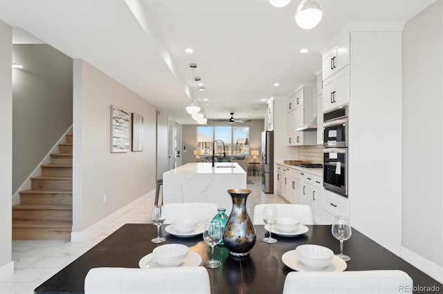 dining space with ceiling fan and sink