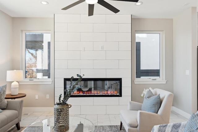 living room with a large fireplace and ceiling fan