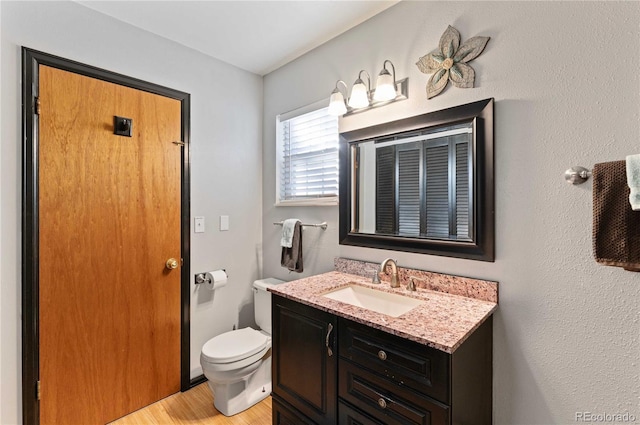 bathroom featuring hardwood / wood-style floors, vanity, and toilet