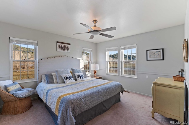 bedroom featuring light carpet, multiple windows, and ceiling fan