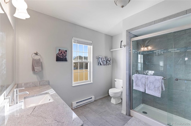 bathroom with vanity, toilet, a shower with door, and a baseboard heating unit