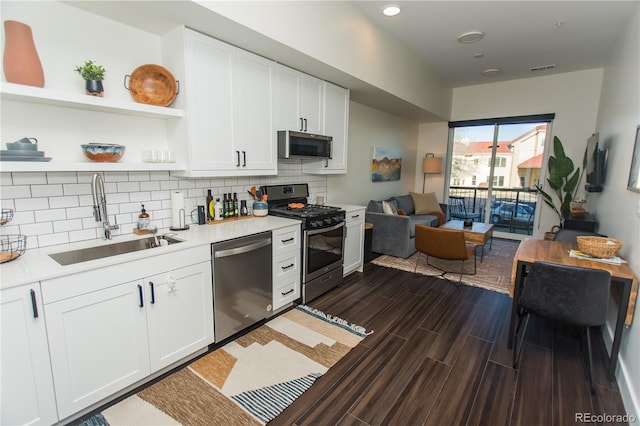 2876 W 53rd Ave Unit 106, Denver, CO 80221 - kitchen featuring appliances with stainless steel finishes, a sink, light countertops, decorative backsplash, and white cabinets