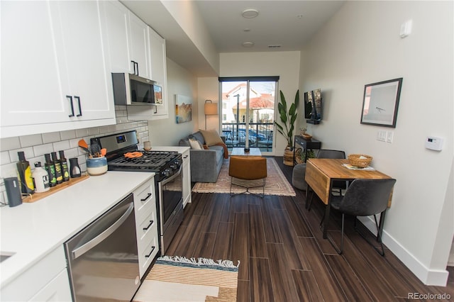 2876 W 53rd Ave Unit 106, Denver, CO 80221 - kitchen featuring stainless steel appliances, light countertops, white cabinetry, and decorative backsplash