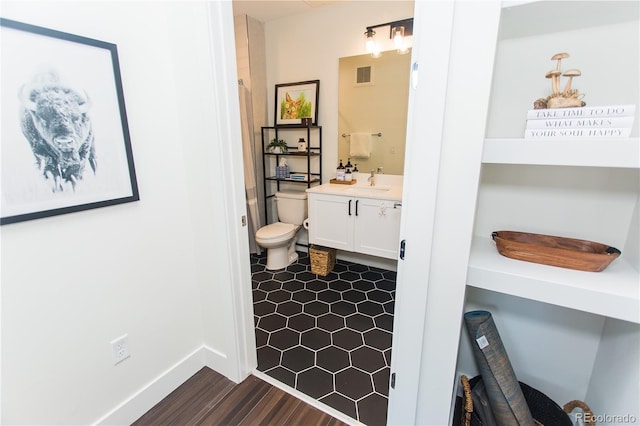 2876 W 53rd Ave Unit 106, Denver, CO 80221 - full bathroom featuring vanity, toilet, wood finished floors, and baseboards