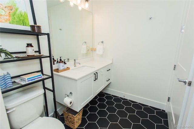 2876 W 53rd Ave Unit 106, Denver, CO 80221 - bathroom featuring vanity, toilet, baseboards, and tile patterned floors