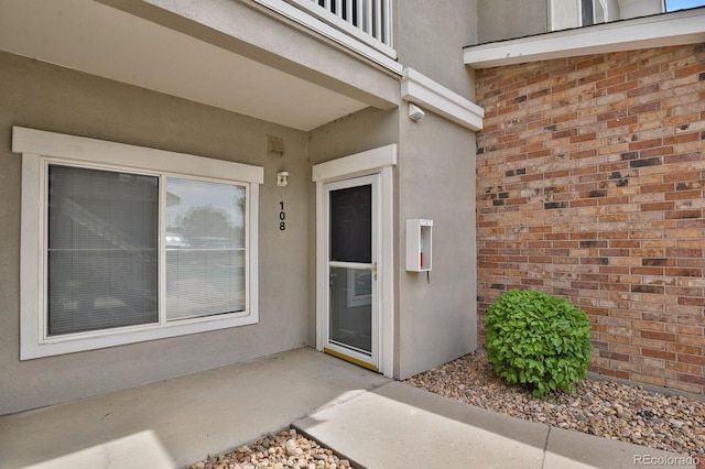 1801 S Dunkirk St Unit 108, Aurora, CO 80017 - doorway to property featuring stucco siding and brick siding