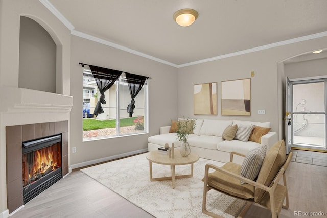 1801 S Dunkirk St Unit 108, Aurora, CO 80017 - living area with arched walkways, wood finished floors, crown molding, and a tiled fireplace