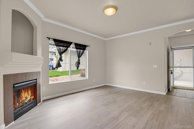 1801 S Dunkirk St Unit 108, Aurora, CO 80017 - unfurnished living room with wood finished floors, crown molding, a tiled fireplace, and arched walkways