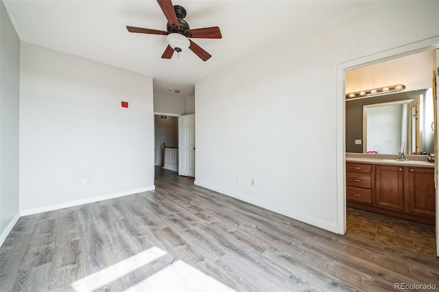 18726 E Yale Cir Unit D, Aurora, CO 80013 - unfurnished bedroom featuring wood finished floors, connected bathroom, baseboards, and a sink