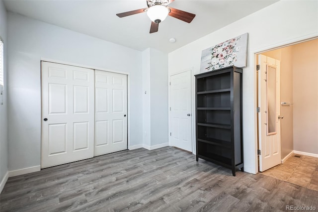 18726 E Yale Cir Unit D, Aurora, CO 80013 - unfurnished bedroom with baseboards, wood finished floors, a closet, and a ceiling fan