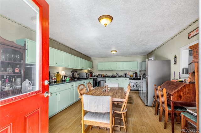237 Foxtail Ct, Fairplay, CO 80440 - kitchen with appliances with stainless steel finishes, dark countertops, a textured ceiling, light wood-style flooring, and crown molding