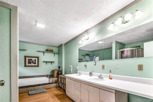 237 Foxtail Ct, Fairplay, CO 80440 - bathroom with a textured ceiling, a bath, double vanity, a textured wall, and wood finished floors