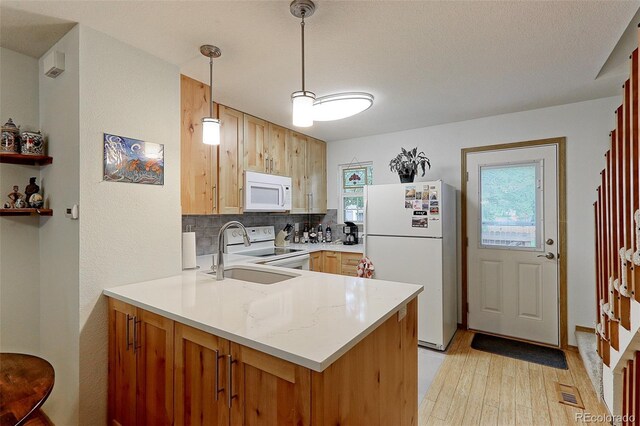 kitchen with white appliances, light hardwood / wood-style flooring, tasteful backsplash, decorative light fixtures, and sink