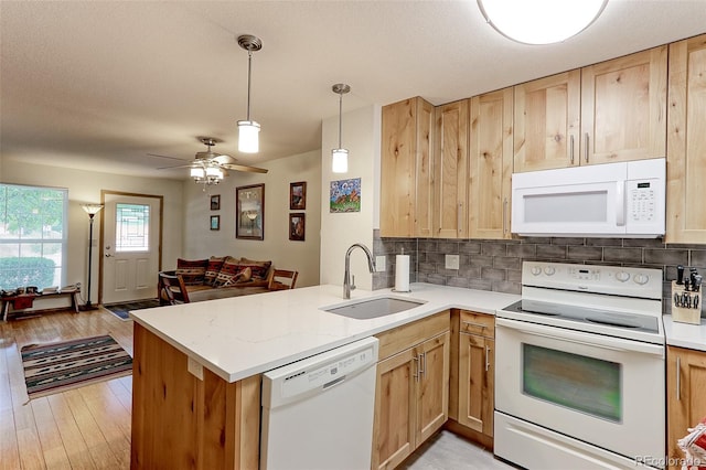 kitchen with white appliances, light hardwood / wood-style flooring, kitchen peninsula, sink, and ceiling fan