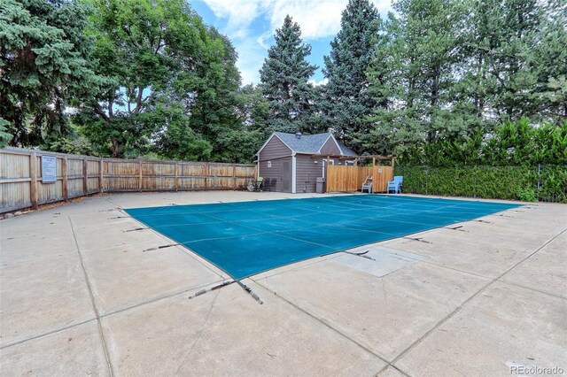 view of swimming pool with an outbuilding and a patio area