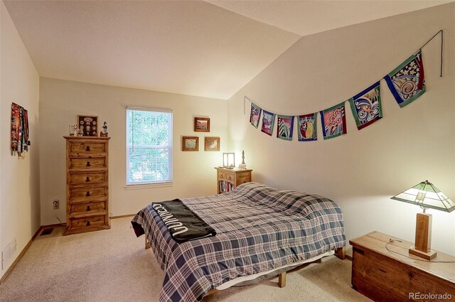 bedroom with light colored carpet and vaulted ceiling