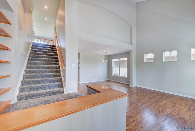 8545 Braun Loop, Arvada, CO 80005 - stairway with plenty of natural light, wood finished floors, a high ceiling, baseboards, and recessed lighting