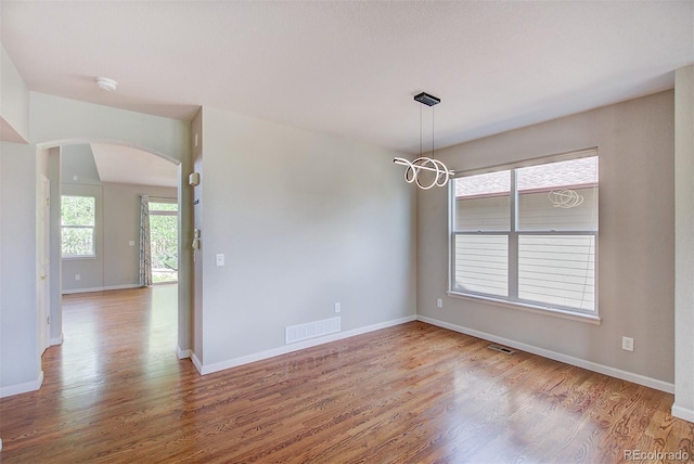 8545 Braun Loop, Arvada, CO 80005 - empty room featuring arched walkways, wood finished floors, baseboards, and a smoke detector