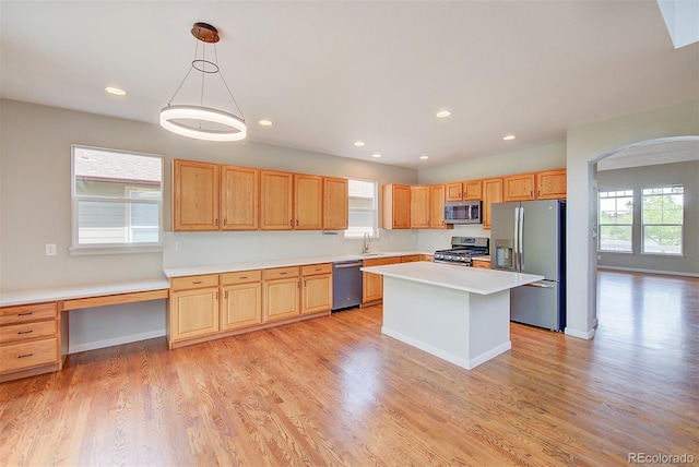 8545 Braun Loop, Arvada, CO 80005 - kitchen featuring stainless steel appliances, arched walkways, a sink, light countertops, and recessed lighting