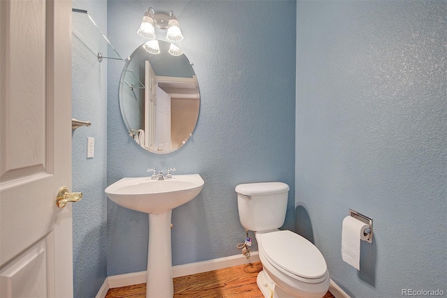 8545 Braun Loop, Arvada, CO 80005 - bathroom featuring wood finished floors, toilet, a sink, and baseboards