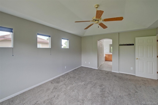 8545 Braun Loop, Arvada, CO 80005 - unfurnished bedroom with arched walkways, light carpet, baseboards, ensuite bath, and ceiling fan