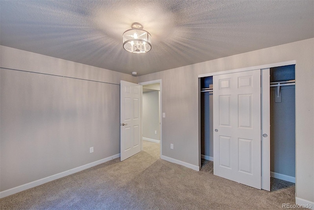 8545 Braun Loop, Arvada, CO 80005 - unfurnished bedroom featuring carpet flooring, a chandelier, baseboards, a closet, and a textured ceiling