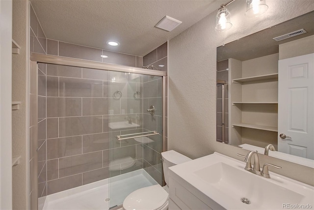 8545 Braun Loop, Arvada, CO 80005 - bathroom featuring a stall shower, toilet, a textured ceiling, a textured wall, and vanity