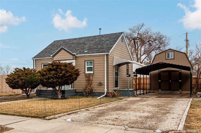 view of front of property with a carport, a storage unit, and a front lawn