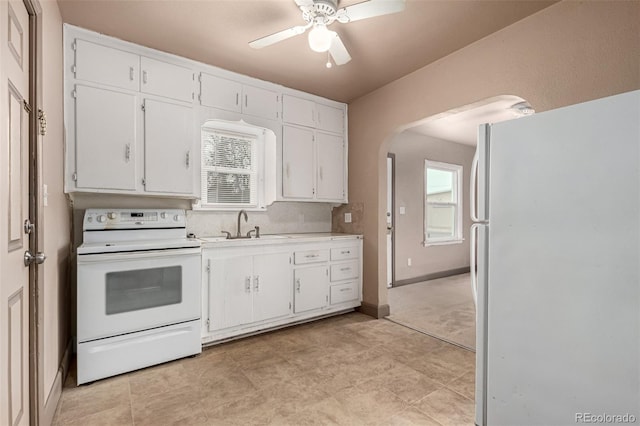 kitchen featuring sink, white appliances, and white cabinets