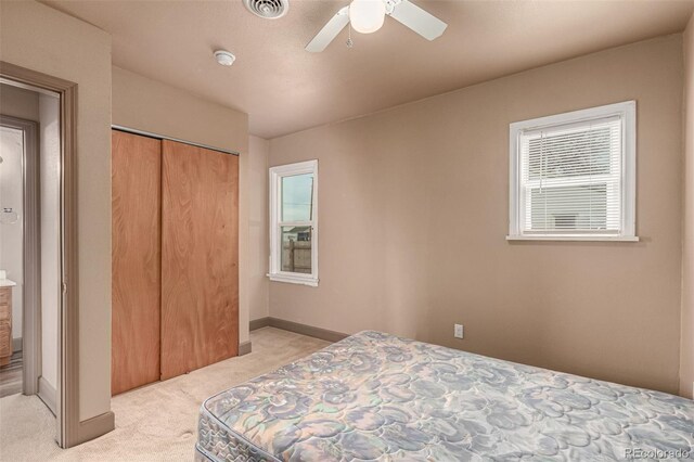 bedroom with light carpet, a closet, and ceiling fan