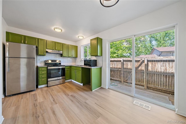 16251 E 17th Pl Unit C, Aurora, CO 80011 - kitchen with green cabinets, appliances with stainless steel finishes, under cabinet range hood, light wood finished floors, and light countertops