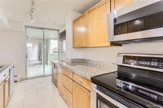 kitchen featuring track lighting, stainless steel appliances, light brown cabinetry, light stone counters, and light tile patterned floors