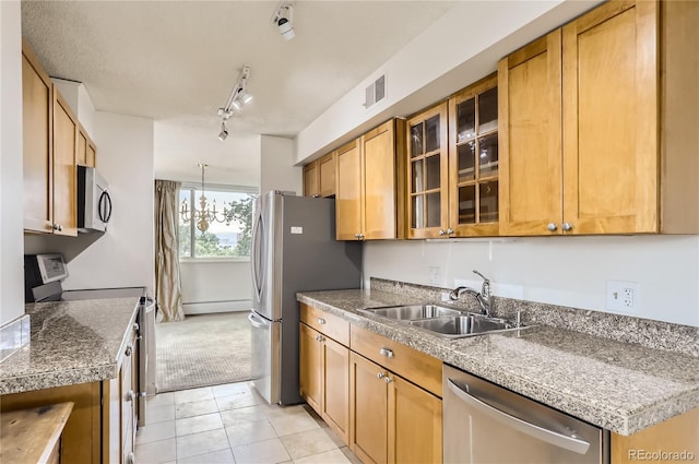 kitchen with a notable chandelier, sink, stainless steel appliances, light tile patterned floors, and rail lighting