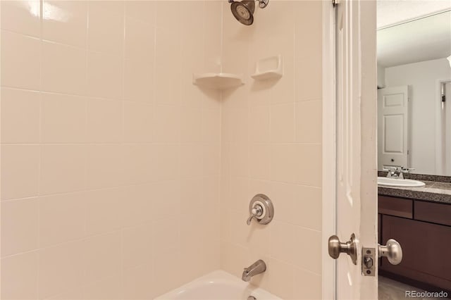 bathroom with tiled shower / bath combo and vanity