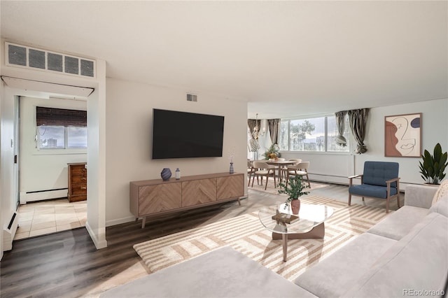 living room with a notable chandelier, hardwood / wood-style flooring, and a baseboard radiator