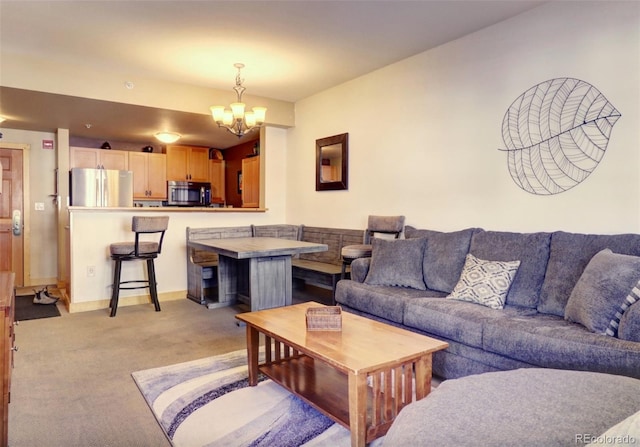 living room with light carpet, baseboards, and a notable chandelier