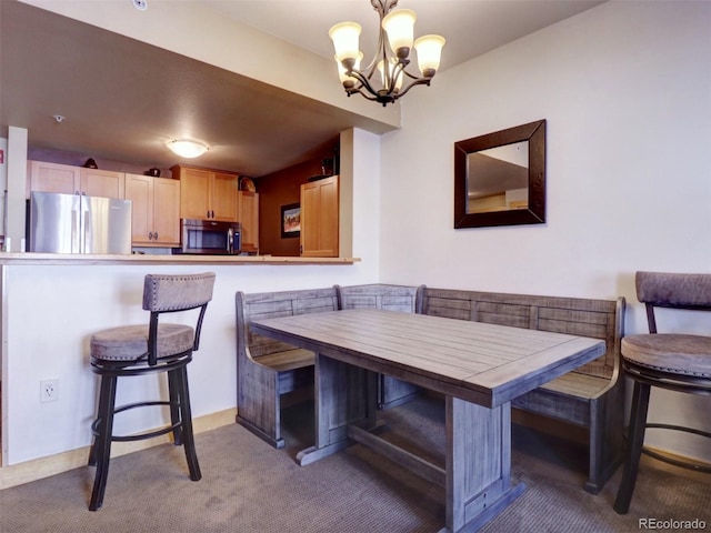 carpeted dining room featuring breakfast area and a notable chandelier