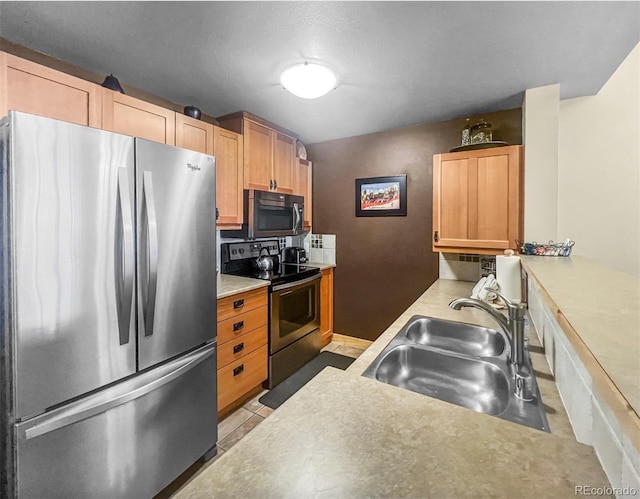 kitchen with stainless steel appliances, a sink, and light countertops