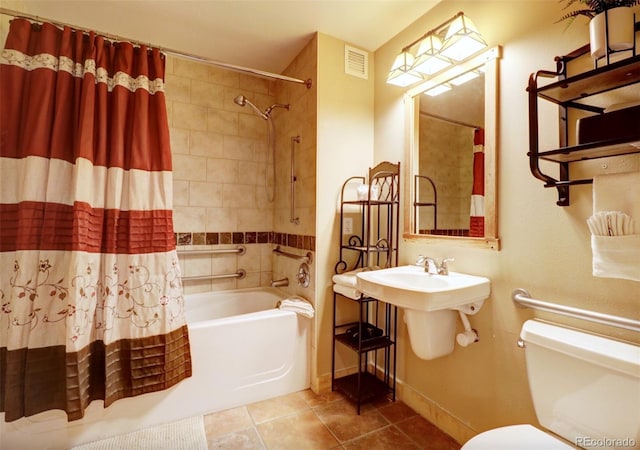 bathroom with visible vents, toilet, shower / bath combo with shower curtain, tile patterned flooring, and baseboards